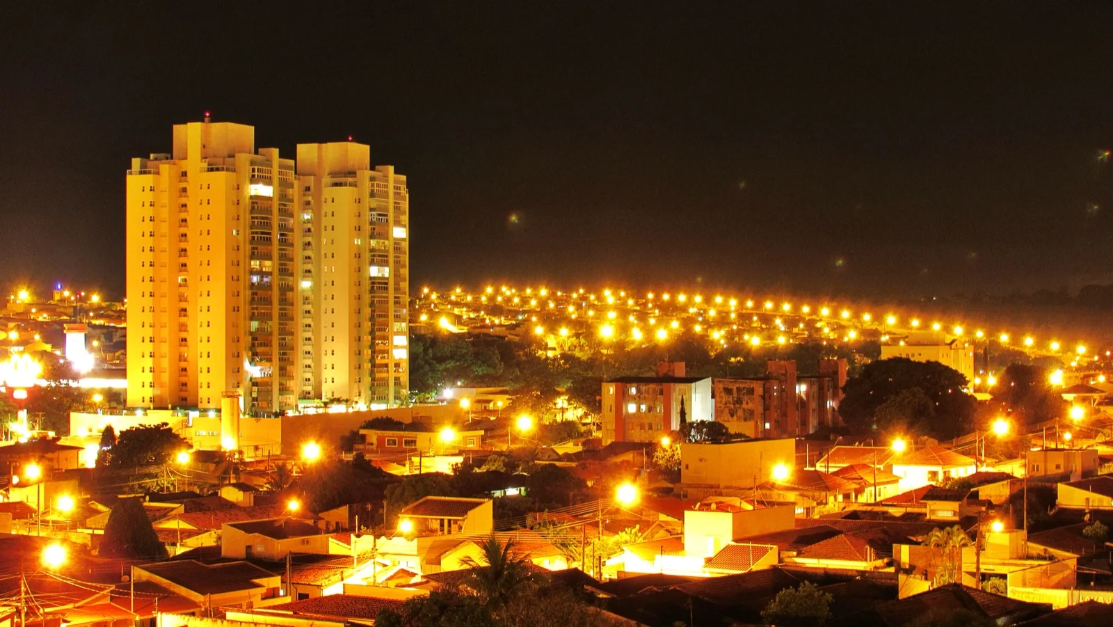 Vista noturna de Araras (SP), com o Edifício Vitrallis iluminado e a cidade ao fundo