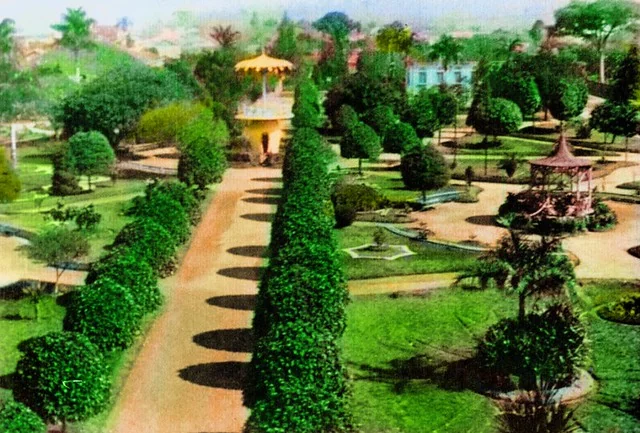 Fotografia antiga colorizada de um parque em Araras SP, com coreto e alamedas de árvores